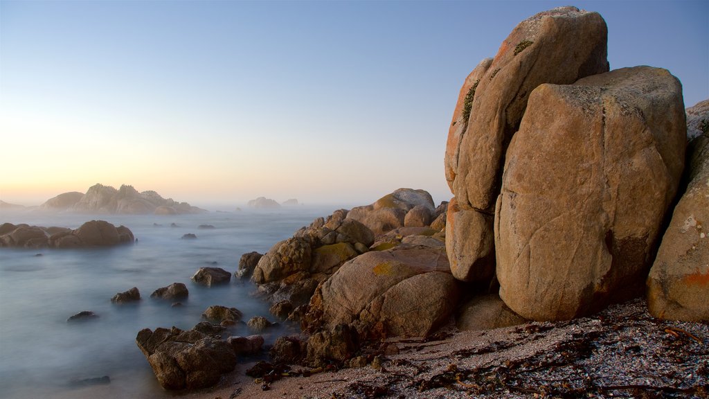 Cape Columbine Lighthouse showing a pebble beach, rugged coastline and mist or fog