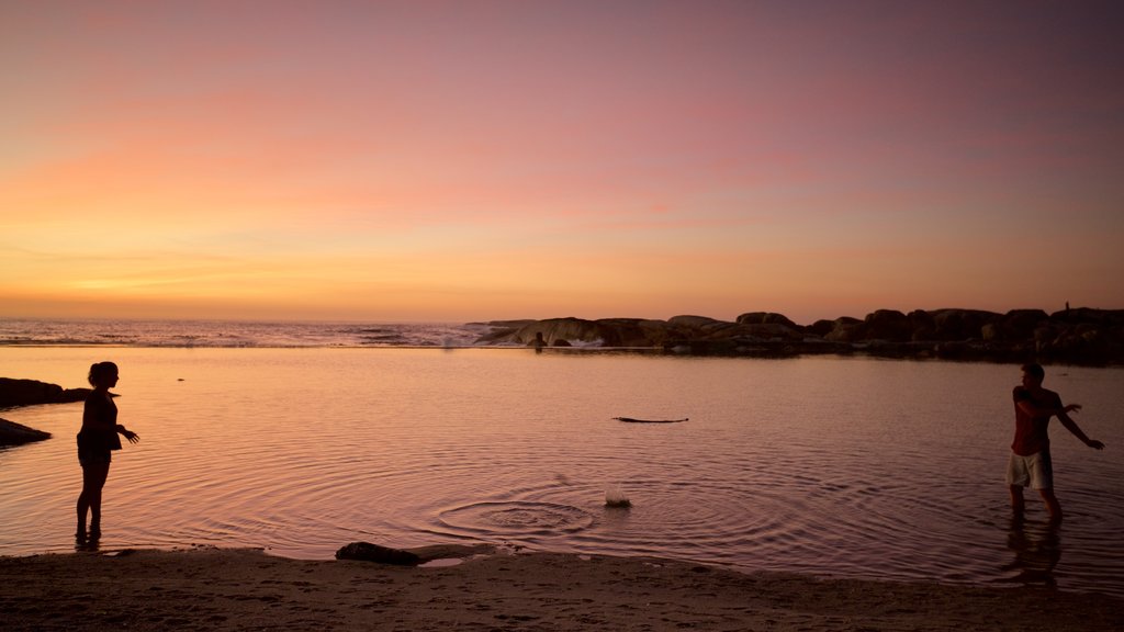 Camps Bay Beach featuring a sandy beach and a sunset as well as a couple