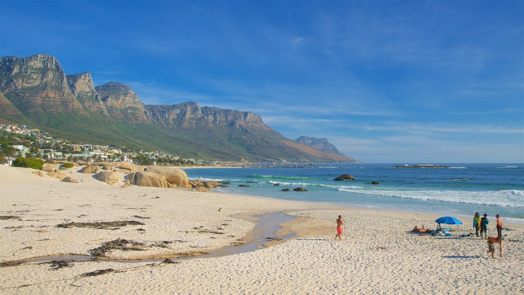 Camps Bay Beach som viser en strand og en kystby såvel som en familie