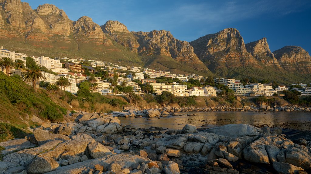 Camps Bay Beach which includes a coastal town and rocky coastline