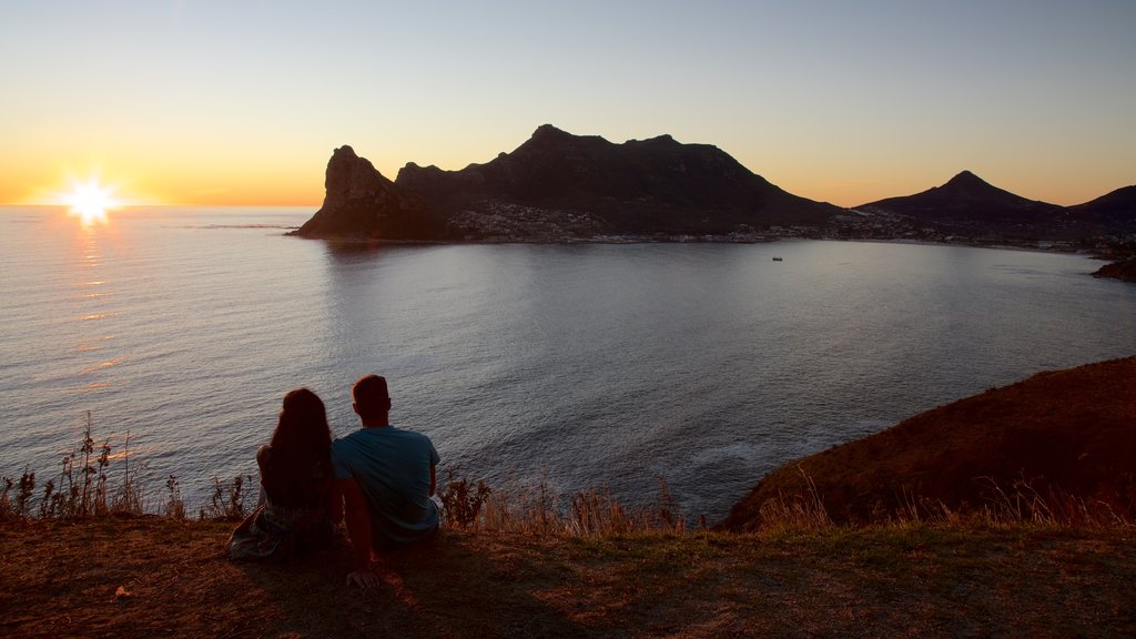 Chapmans Peak mostrando costa escarpada y una puesta de sol y también una pareja