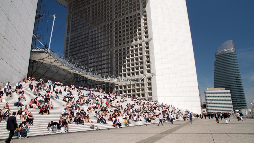 La Défense ofreciendo un parque o plaza y una ciudad y también un gran grupo de personas