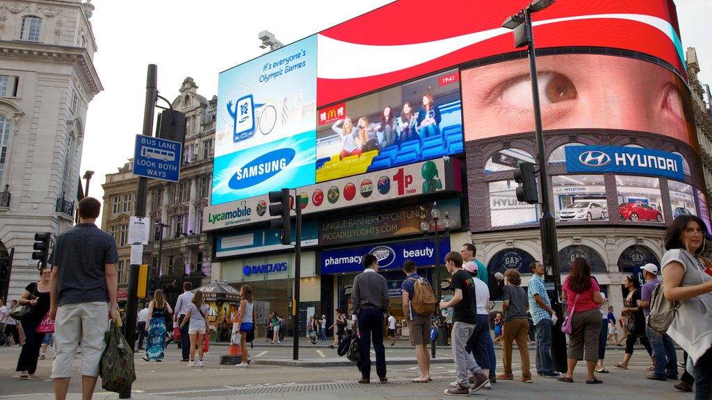 Piccadilly Circus mostrando señalización y una ciudad y también un gran grupo de personas