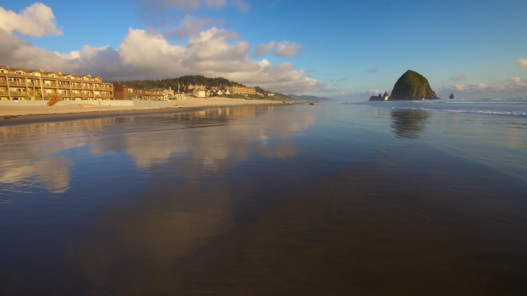 Cannon Beach which includes a sandy beach, landscape views and a coastal town