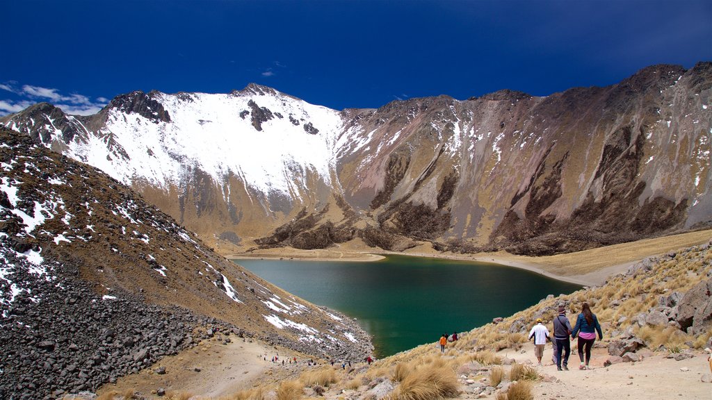 Nevado de Toluca National Park featuring a lake or waterhole and hiking or walking as well as a small group of people