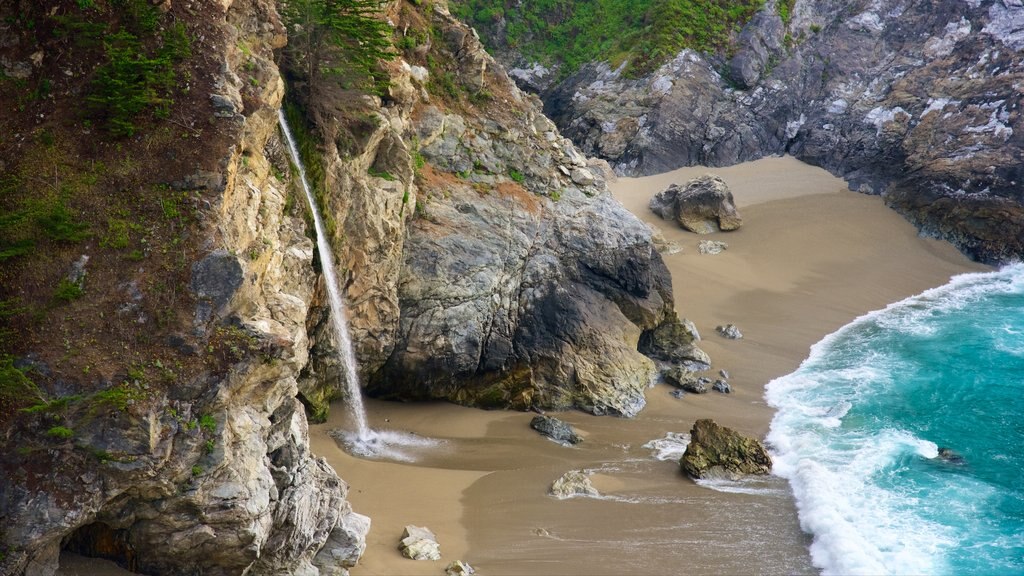 McWay Falls featuring rugged coastline and a sandy beach