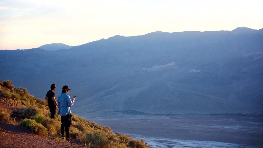 Death Valley som viser kløft eller juv og rolig landskap i tillegg til en liten gruppe med mennesker