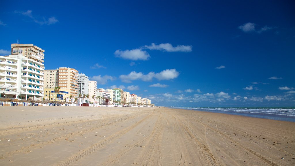 Playa de la Victoria que incluye una playa de arena y una ciudad costera