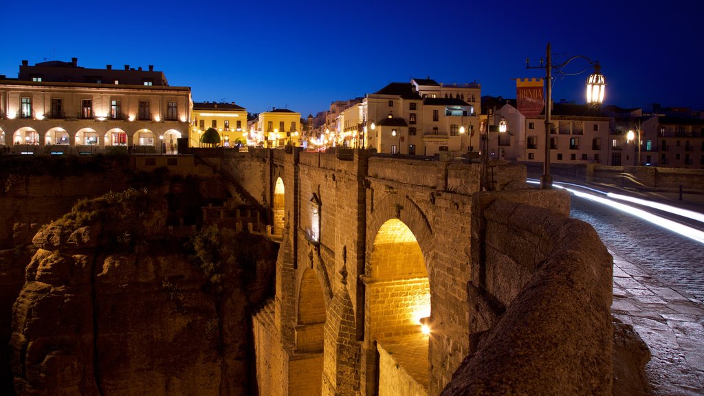 Puente Nuevo showing a bridge, night scenes and heritage elements