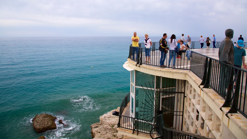 Balcón de Europa que incluye vista general a la costa y vista y también un gran grupo de personas