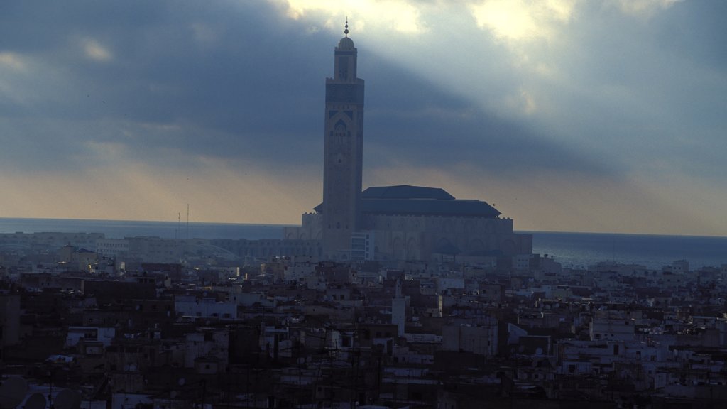 Marrocos que inclui um pôr do sol, uma cidade e uma igreja ou catedral