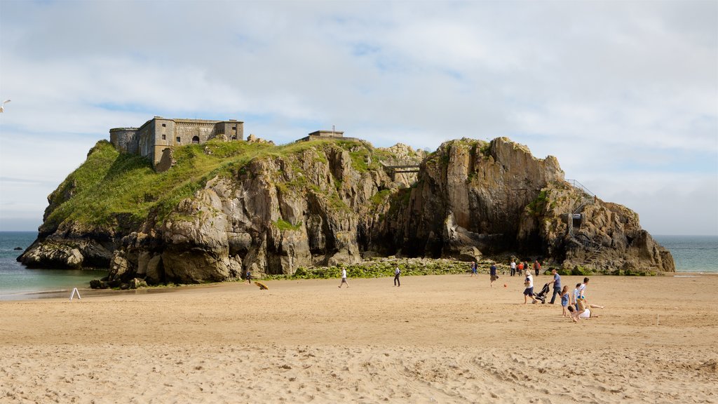 Tenby showing rocky coastline, a beach and a castle