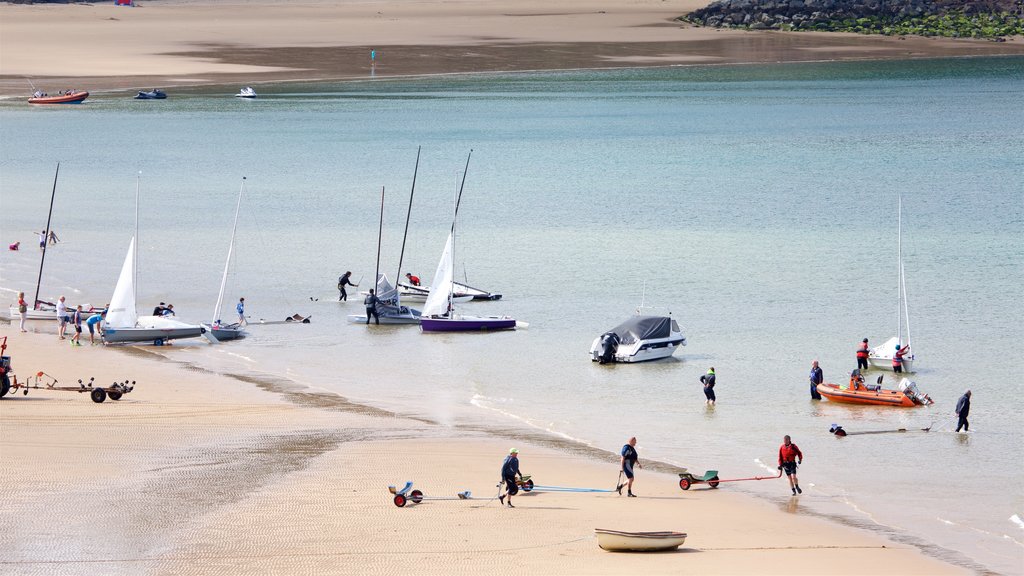 Tenby que incluye una playa, botes y una bahía o un puerto