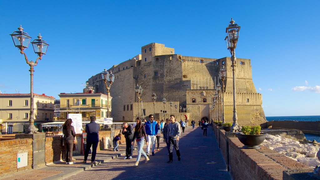 Castel dell\'Ovo mostrando elementos del patrimonio y un castillo y también un pequeño grupo de personas