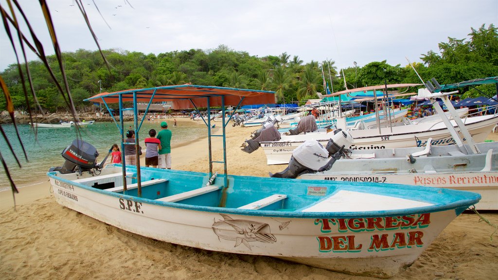 Praia Puerto Angelito que inclui uma praia, uma baía ou porto e paisagens litorâneas