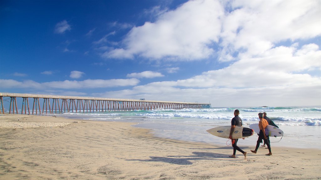 Rosarito strand som viser strand og surfing i tillegg til en liten gruppe med mennesker