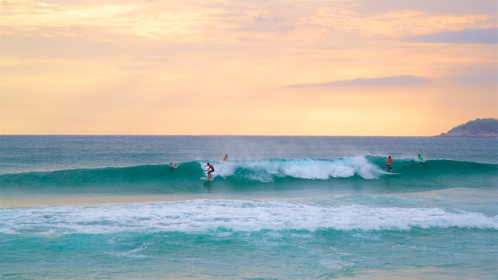 Zicatela Beach showing a sunset, skyline and surfing