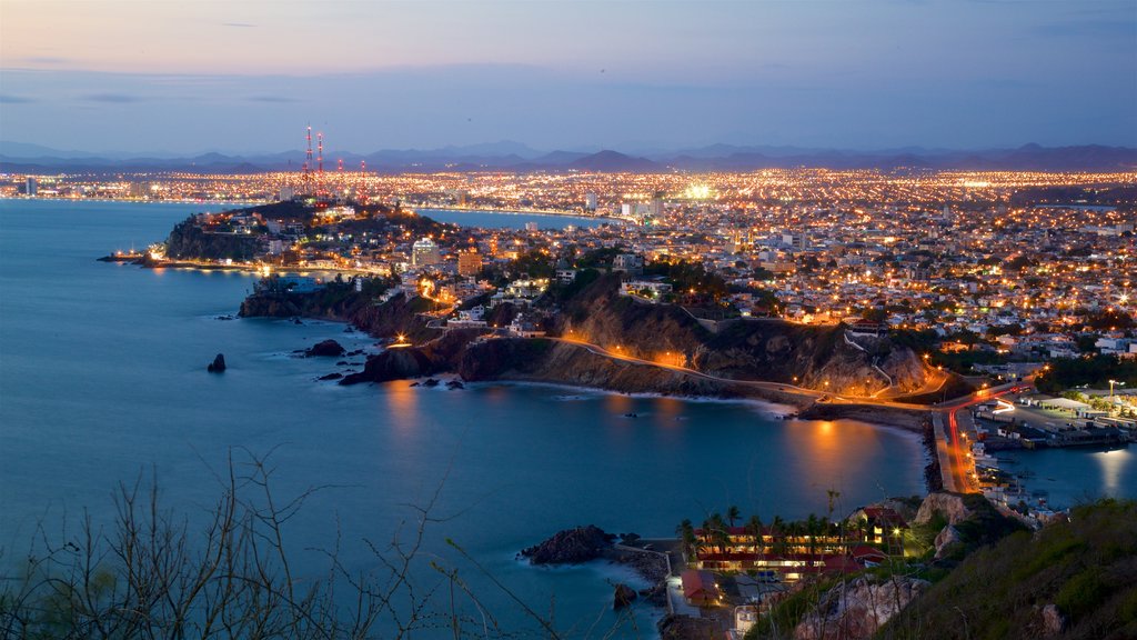 El Faro Lighthouse showing a city, night scenes and general coastal views