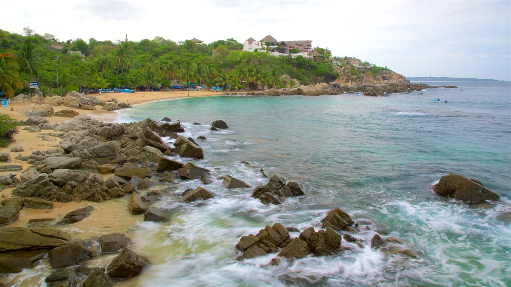 Playa Puerto Angelito que incluye costa escarpada, vista general a la costa y una playa de arena