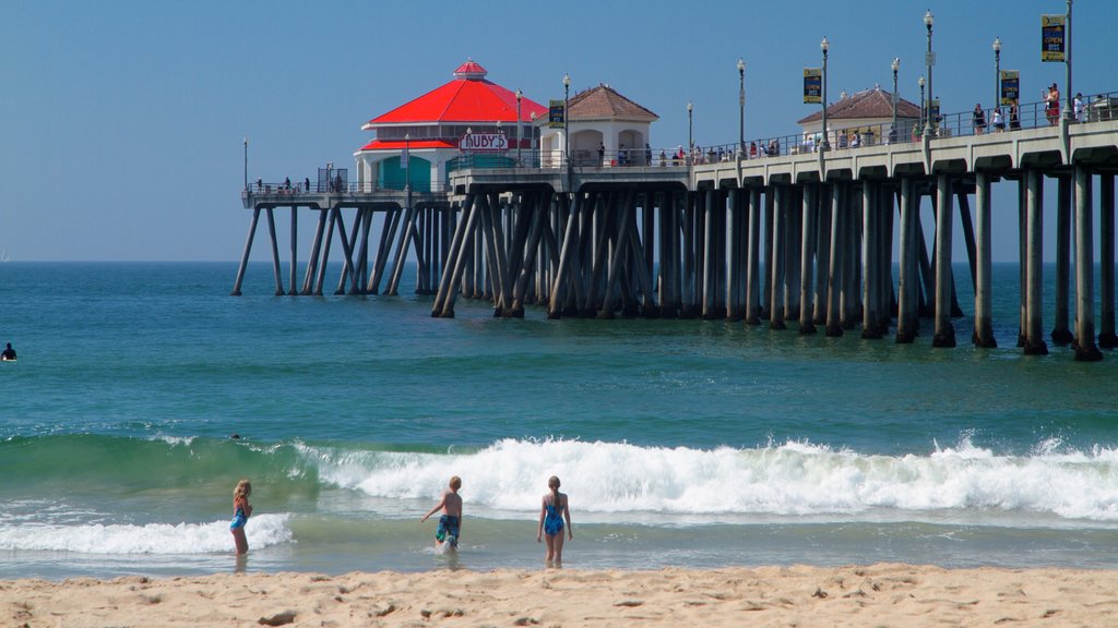 Huntington Beach ofreciendo vista panorámica y una playa y también un pequeño grupo de personas