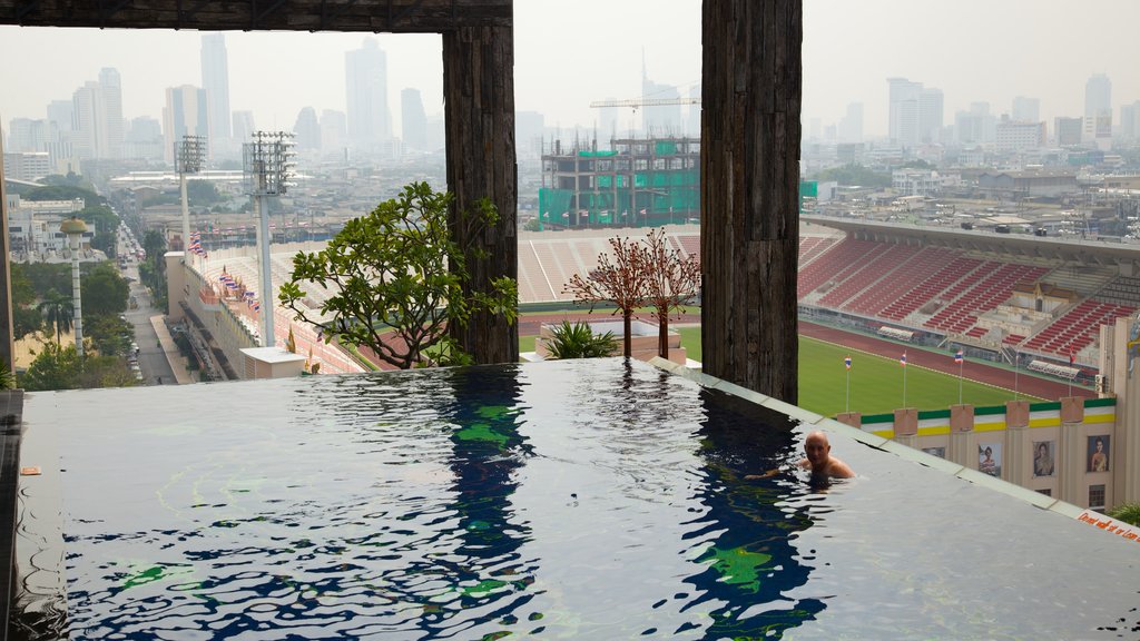 Bangkok som omfatter en pool og en by såvel som en mand