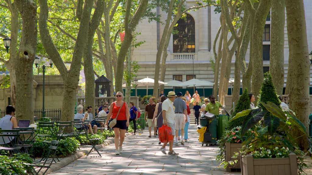 Bryant Park featuring a garden as well as a small group of people