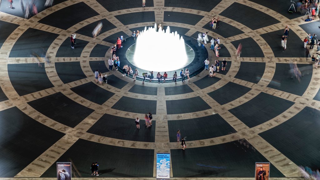 Lincoln Center for the Performing Arts which includes a square or plaza and a fountain as well as a small group of people