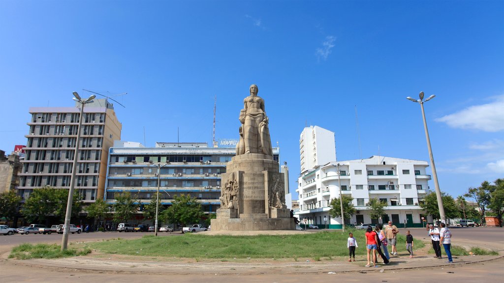 Maputo caracterizando uma estátua ou escultura assim como um pequeno grupo de pessoas