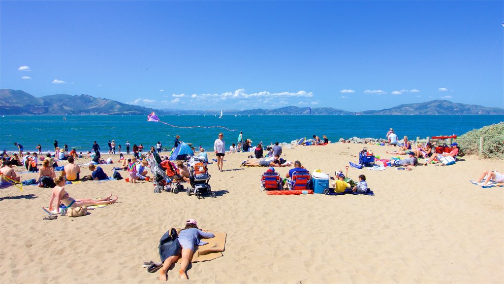 Crissy Field which includes general coastal views and a beach as well as a large group of people