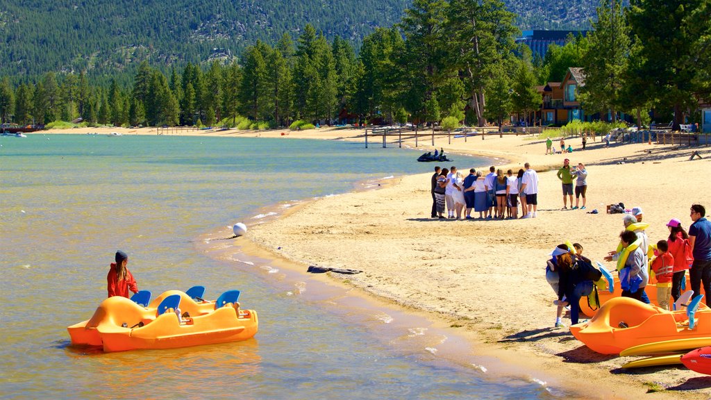 South Lake Tahoe som omfatter en sandstrand og udsigt over kystområde såvel som en lille gruppe mennesker