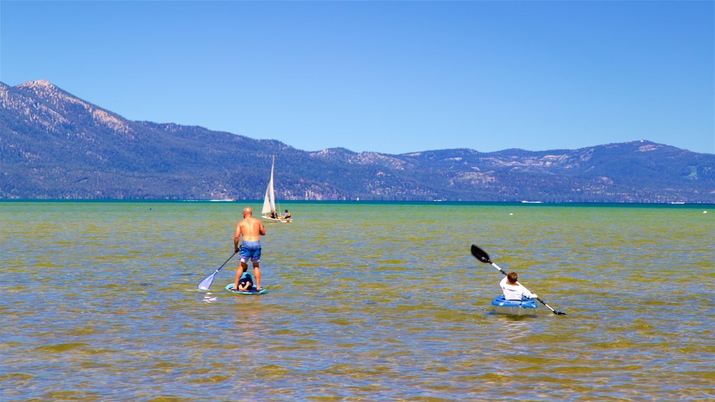 Lago Tahoe sur que incluye kayaks o canoas y vista general a la costa y también una familia