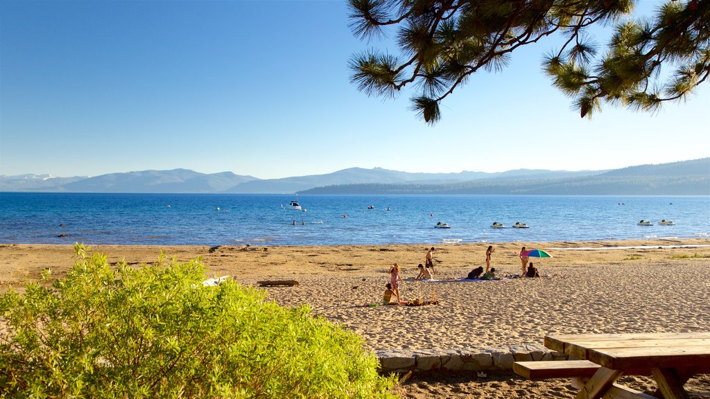 Zona recreativa estatal Kings Beach que incluye una playa y vista general a la costa y también un pequeño grupo de personas