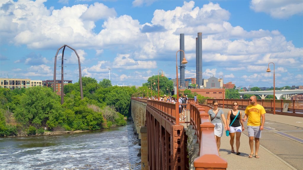 Minneapolis - St. Paul que inclui um rio ou córrego e uma ponte assim como um pequeno grupo de pessoas