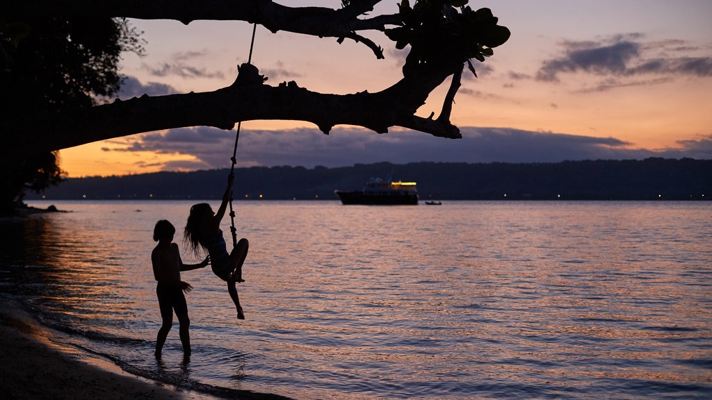 Aore Island que inclui paisagens litorâneas e um pôr do sol assim como crianças