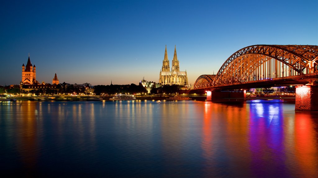 Ponte Hohenzollern mostrando uma ponte, um rio ou córrego e um pôr do sol