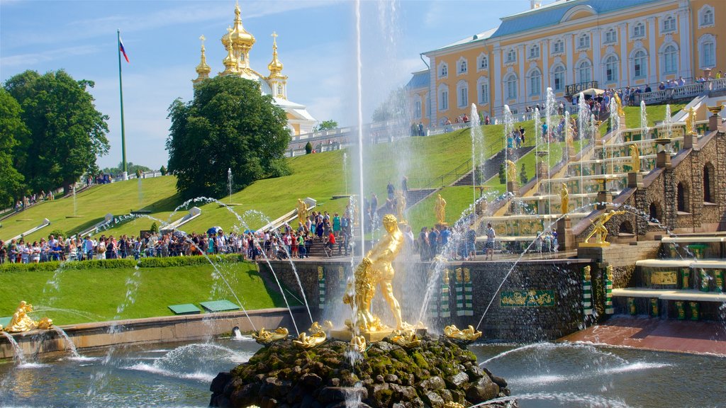 Peterhof-paladset og haven som viser en have og et springvand såvel som en lille gruppe mennesker