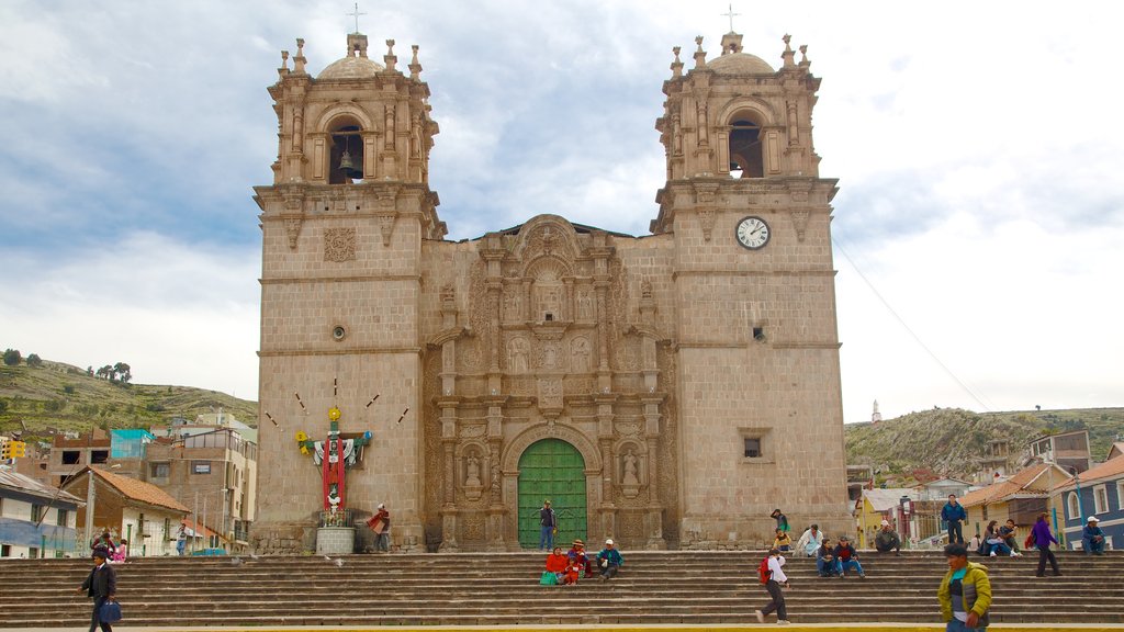 Lake Titicaca showing a church or cathedral and heritage architecture as well as a small group of people