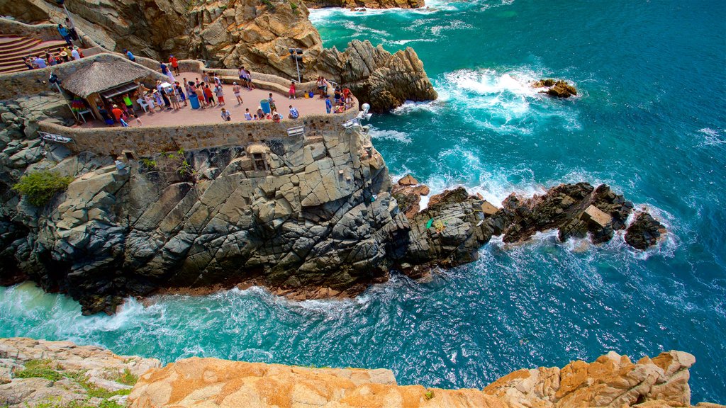 La Quebrada Cliffs featuring rocky coastline as well as a small group of people