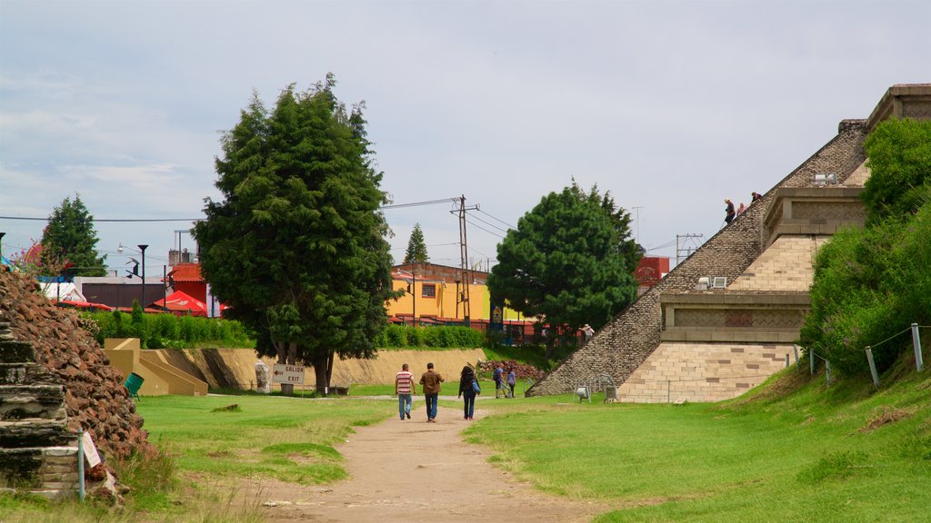 Gran Pirámide de Cholula mostrando elementos patrimoniales y jardín y también un pequeño grupo de personas