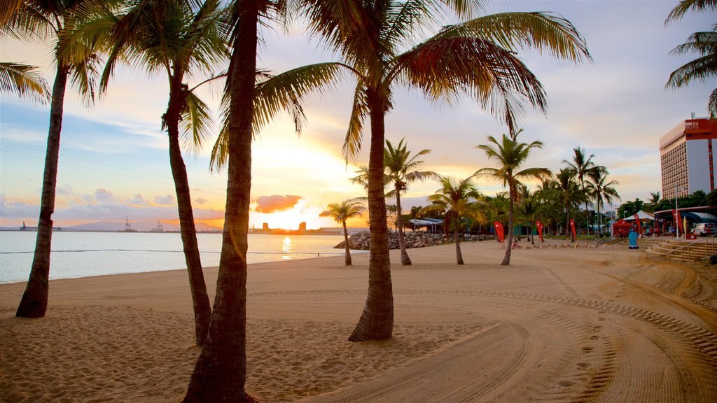 The Strand ofreciendo una puesta de sol, una playa y escenas tropicales