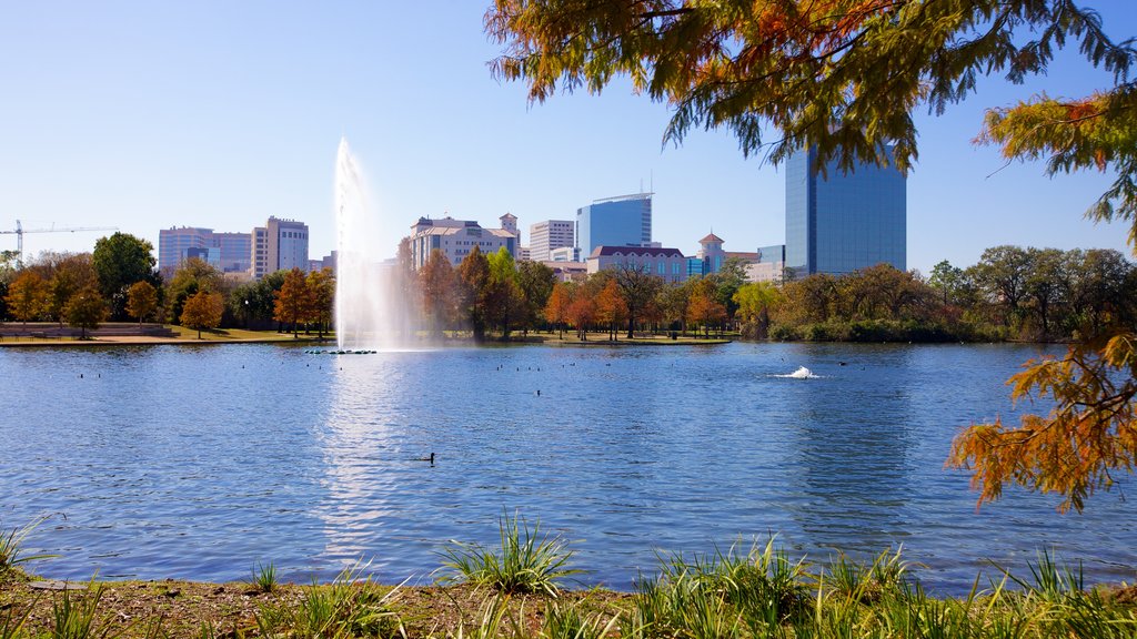 Hermann Park featuring a fountain, skyline and fall colors