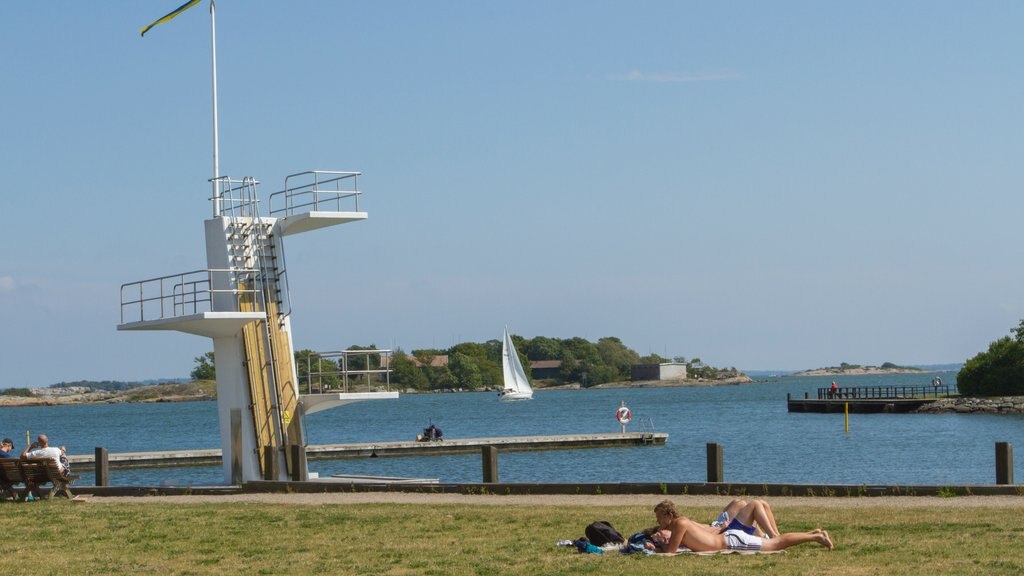 Karlskrona ofreciendo jardín y un lago o espejo de agua y también un pequeño grupo de personas