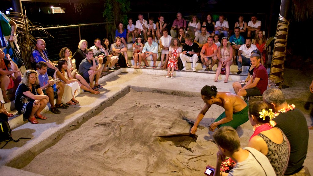 Centro cultural Tiki Village ofreciendo arte escénica y también un pequeño grupo de personas