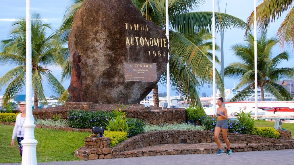 Papeete which includes signage and a park as well as an individual female