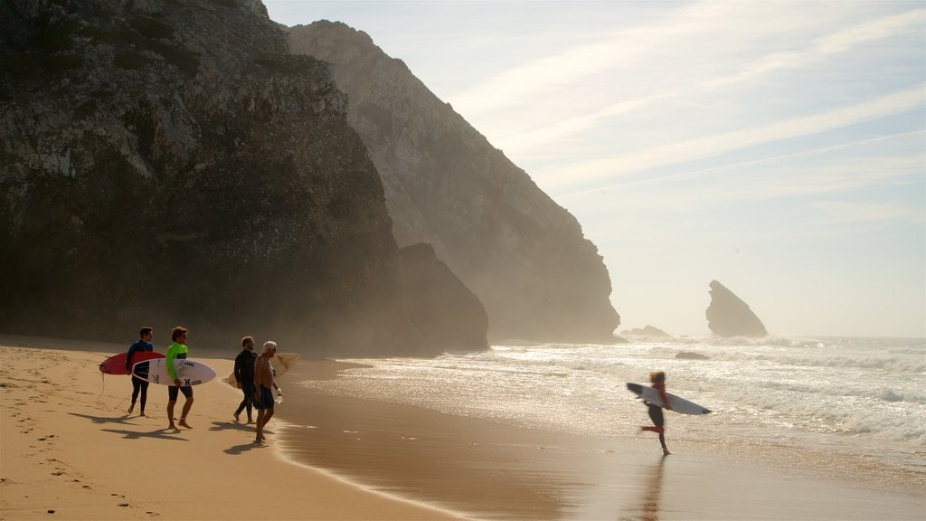 Adraga Beach which includes a beach, waves and a sunset