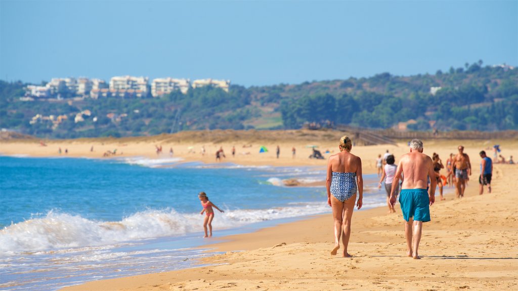 Alvor Beach showing general coastal views and a sandy beach as well as a couple