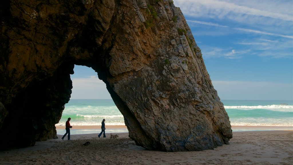 Adraga Beach featuring surf, rugged coastline and a beach