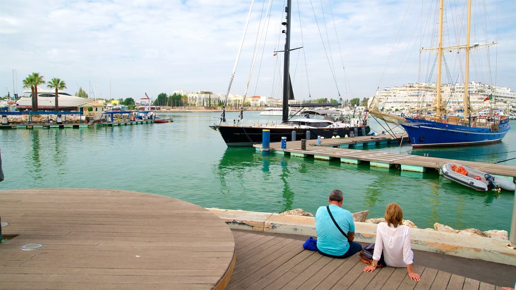 Vilamoura Marina showing a bay or harbour as well as a couple