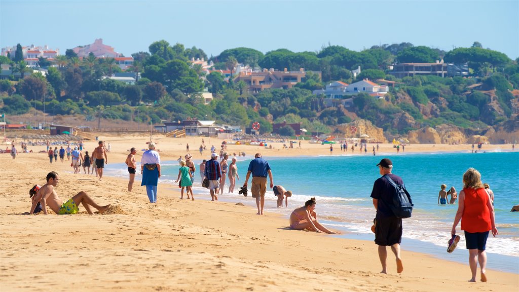 Playa de Alvor que incluye una playa y vista general a la costa y también un pequeño grupo de personas