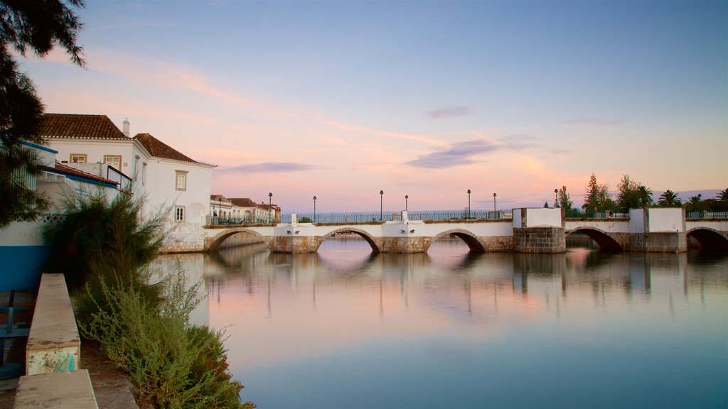 Puente romano que incluye un puente, un atardecer y un río o arroyo